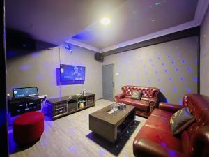 sala de estar con sofá y TV en B04 Modern Deluxe Homestay, en Johor Bahru