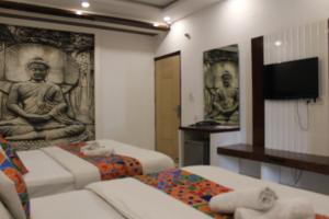 a room with two beds and a flat screen tv at Hindustan by Backpackers Heaven Near New Delhi Railway Station in New Delhi