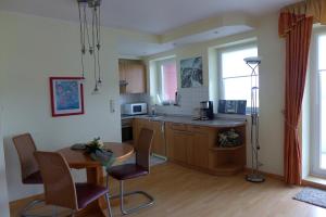 cocina con mesa, mesa y sillas en Tief 10 Seenebel mit Internet 303, en Wangerland