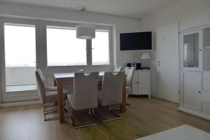 a dining room with a table and chairs at Tief 10 Meeresstern mit Internet504 in Wangerland