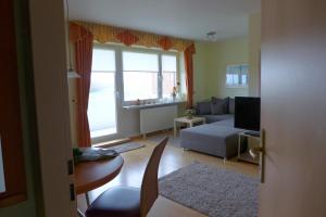 Una sala de estar con un sofá y una ventana. en Tief 10 Seenebel mit Internet 303, en Wangerland