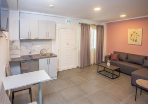 a kitchen and a living room with a couch and a table at Privileged villa in Nea Peramos
