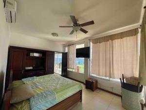 a bedroom with a bed and a ceiling fan at Villa Florita Beach House in El Remate