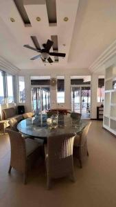 a dining room with a table and chairs and a ceiling fan at Villa Florita Beach House in El Remate