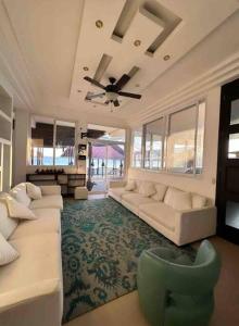 a living room with couches and a ceiling fan at Villa Florita Beach House in El Remate