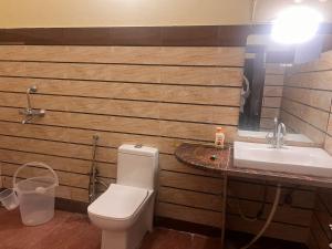 a bathroom with a toilet and a sink at The HeartWood Farms Inn in Rāmnagar