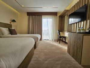 een hotelkamer met 2 bedden en een bureau bij Edom Hotel in Wadi Musa