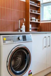 una lavadora en una cocina junto a una barra en Hills Serenity w Private Creek, en Aldgate