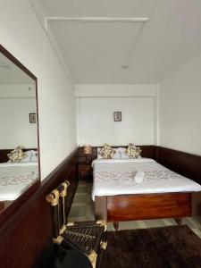 1 dormitorio con 2 camas y un espejo grande en Monratino Ridge View, en Gangtok