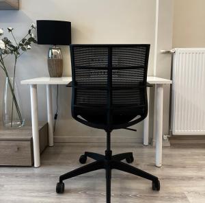 a black office chair sitting in front of a desk at Deluxe City Apartment in Athens