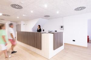 Eine Frau, die an einer Theke in einem Büro steht. in der Unterkunft Hotel Costa Brava in Roses