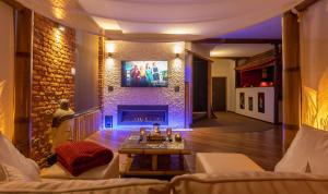 a living room with a fireplace and a tv at Le Baiser de Shogun in Ensival