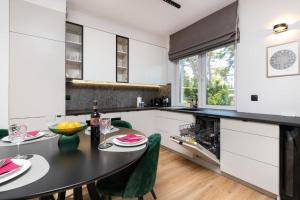 a kitchen with a black table and green chairs at Double Rest in Jastrzębia Góra