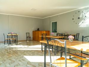 a dining room with tables and chairs and a wall at Orenda in Telavi