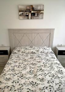 een slaapkamer met een bed met een bloemenbed bij Alojamiento céntrico con encanto in Ferrol