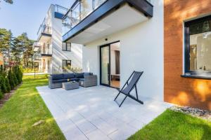 a patio with a couch and chairs in a yard at Double Rest in Jastrzębia Góra