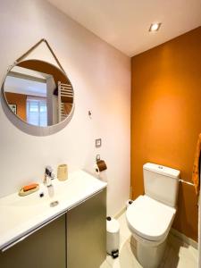 uma casa de banho com um WC e um espelho. em La Maison Forestière em Niederbronn-les-Bains