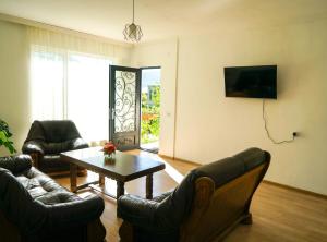 a living room with couches and a table and a window at Orenda in Tʼelavi