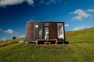 una casita en una colina en un campo en Mighty Tiny House 1, en Ruawaro