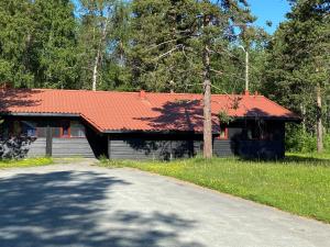 una casa con techo rojo junto a una carretera en Høgtun kulturklynge en Olsborg