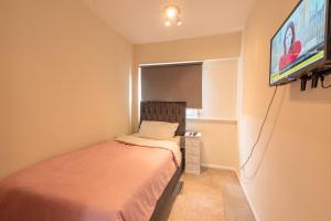 a small bedroom with a bed and a tv at Professional House in Kent