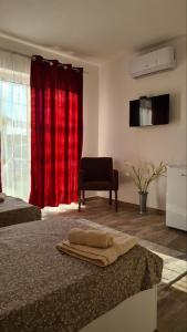ein Schlafzimmer mit 2 Betten und einem roten Vorhang in der Unterkunft Apartmani KOKI Kladovo in Kladovo
