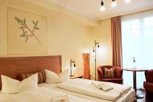 una camera d'albergo con letto e sedia di Pension Sanddorn mit Café Carlssons a Binz