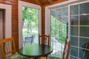 a porch with a table and chairs and a window at Cozy Tennessee Cabin with Deck, Grill and Fire Pit! in Tullahoma