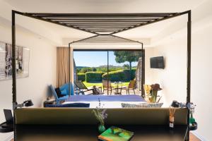 a bedroom with a bed and a view of a patio at Hôtel & Spa Version Maquis Citadelle in Bonifacio