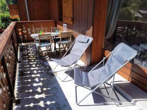 a patio with chairs and a table on a balcony at Charmant Appartement Bozel Centre in Bozel