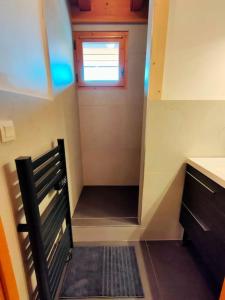 a small room with a staircase leading up to a window at Charmant Appartement Bozel Centre in Bozel +2 photos
