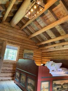 a room with a wooden ceiling with a bed and pictures at Hesla Farm in Gol