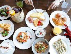 a table topped with white plates of food at The Westin Wenzhou in Wenzhou