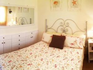 a bedroom with a bed with a floral bedspread at REf 51 APARTAMENTO MARINA in Zahara de los Atunes