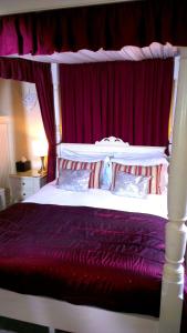a bed that has a red blanket on it at The Bath House Boutique B&B - IN-ROOM Breakfast - FREE parking in Bath