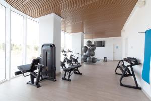 einen Fitnessraum mit Laufbändern und Trainingsgeräten in einem Zimmer in der Unterkunft Global Properties, Apartamento con terraza, vistas al mar y a la piscina in Canet d'en Berenguer