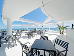 eine Terrasse mit Tischen und Stühlen und Meerblick in der Unterkunft Global Properties, Apartamento con terraza, vistas al mar y a la piscina in Canet d'en Berenguer