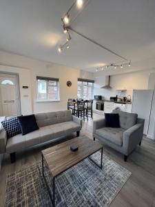 a living room with two couches and a coffee table at Warner Brothers Apartment in Watford