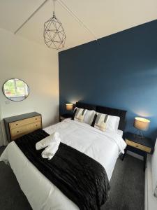 a bedroom with a large bed with a black blanket at Warner Brothers Apartment in Watford