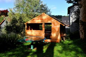 a small wooden cabin with a table in the grass at Ferienapartment am Rennsteig in Lauscha