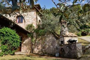 una casa in pietra con un forno in pietra di fronte di Villa Podere Antico con piscina a Civitella Del Lago