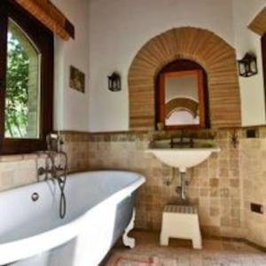 bagno con vasca bianca e lavandino di Villa Podere Antico con piscina a Civitella Del Lago