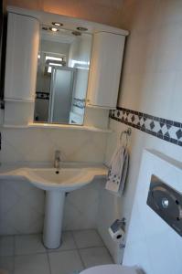 ein Bad mit einem Waschbecken und einem Spiegel in der Unterkunft Kuşadası Muhteşem Deniz Manzaralı Villa 6+1 in Kusadası