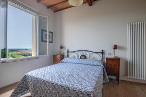 um quarto com uma cama com um edredão azul e uma janela em Porta Romana Elegant House with Private Parking! em Siena