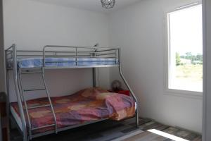 Etagenbett in einem Zimmer mit Fenster in der Unterkunft Montalivet à 1km,Villa(jardin)à 1km plages wifi in Vensac
