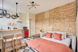 a bedroom with a large bed and a kitchen at Apartment Center of Paris by Studio prestige in Paris