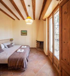 a bedroom with a large bed and a fireplace at Can Passarells in San Vicente de Torelló