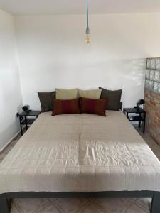 a large white bed in a room with two tables at Somlói Vándor Lodge in Somlóvásárhely