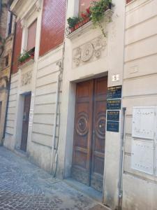 a building with a wooden door on a street at Al comune in Atri