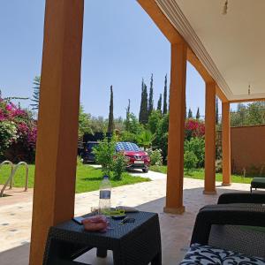 een patio met een tafel en uitzicht op een tuin bij Villa Ama in Marrakesh